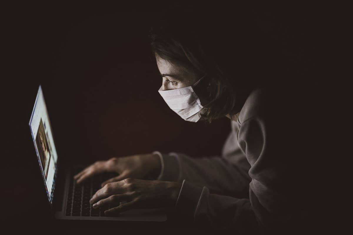 a student studying during the quarantine with a mask on